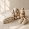 Muslin baby blanket, knitted bunny and wooden toy on linen