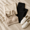 Folded knitwear, leggings and white sneakers on cream linen