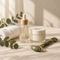 Serum bottle, cream jar and face roller on cream linen